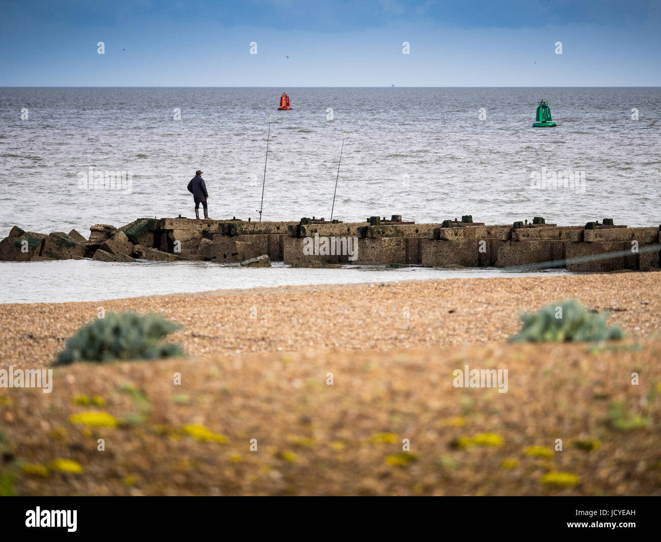 Pêche en mer à partir d'une jetée de roche dans la petite ville balnéaire de Felixstowe, Suffolk, UK Banque D'Images