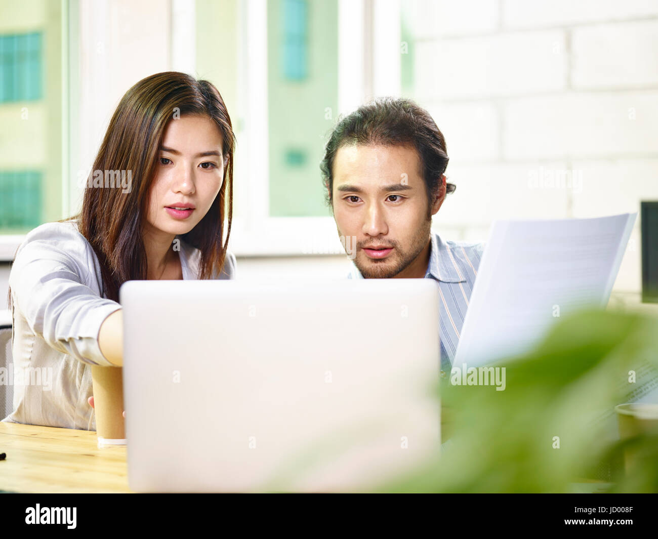 Les jeunes gens d'affaires asiatiques travaillant ensemble dans l'équipe Office à l'aide d'un ordinateur portable. Banque D'Images