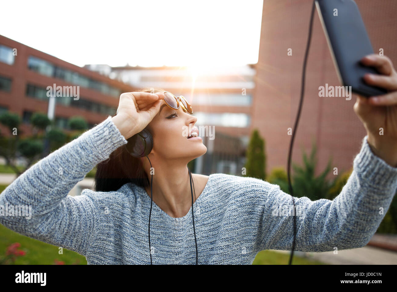 Jeune femme prenant en plein air comprimé par selfies coucher du soleil Banque D'Images