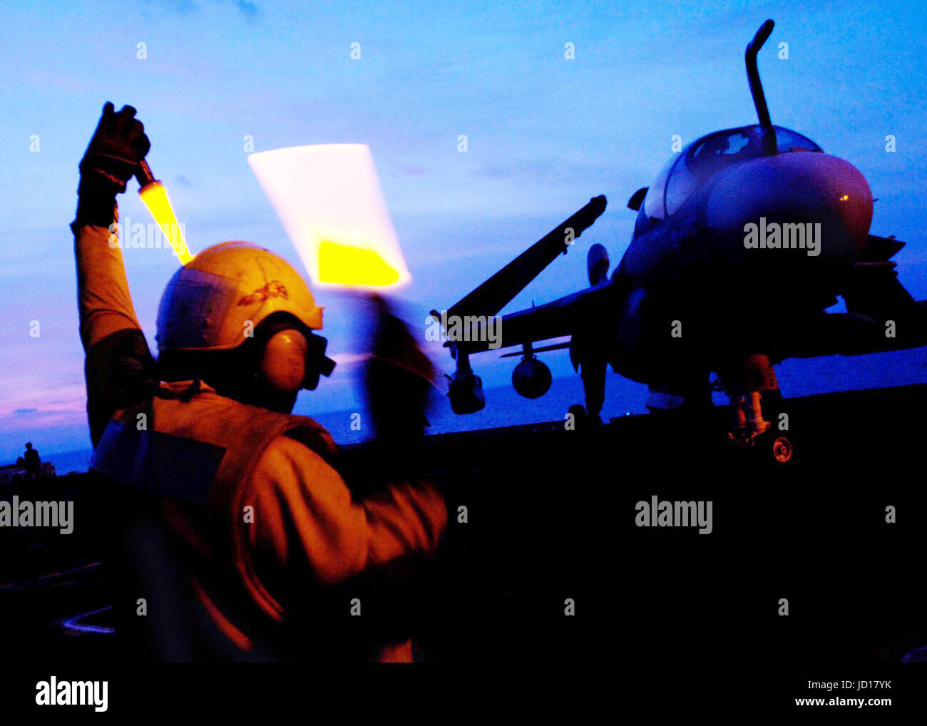 Un Maître de la Marine américaine utilise des baguettes pour diriger les pilotes d'un EA-6B Prowler sur le pont du porte-avions USS Enterprise (CVN 65). DoD photo de Maître de 3e classe de la Marine américaine, Milosz Reterski Banque D'Images
