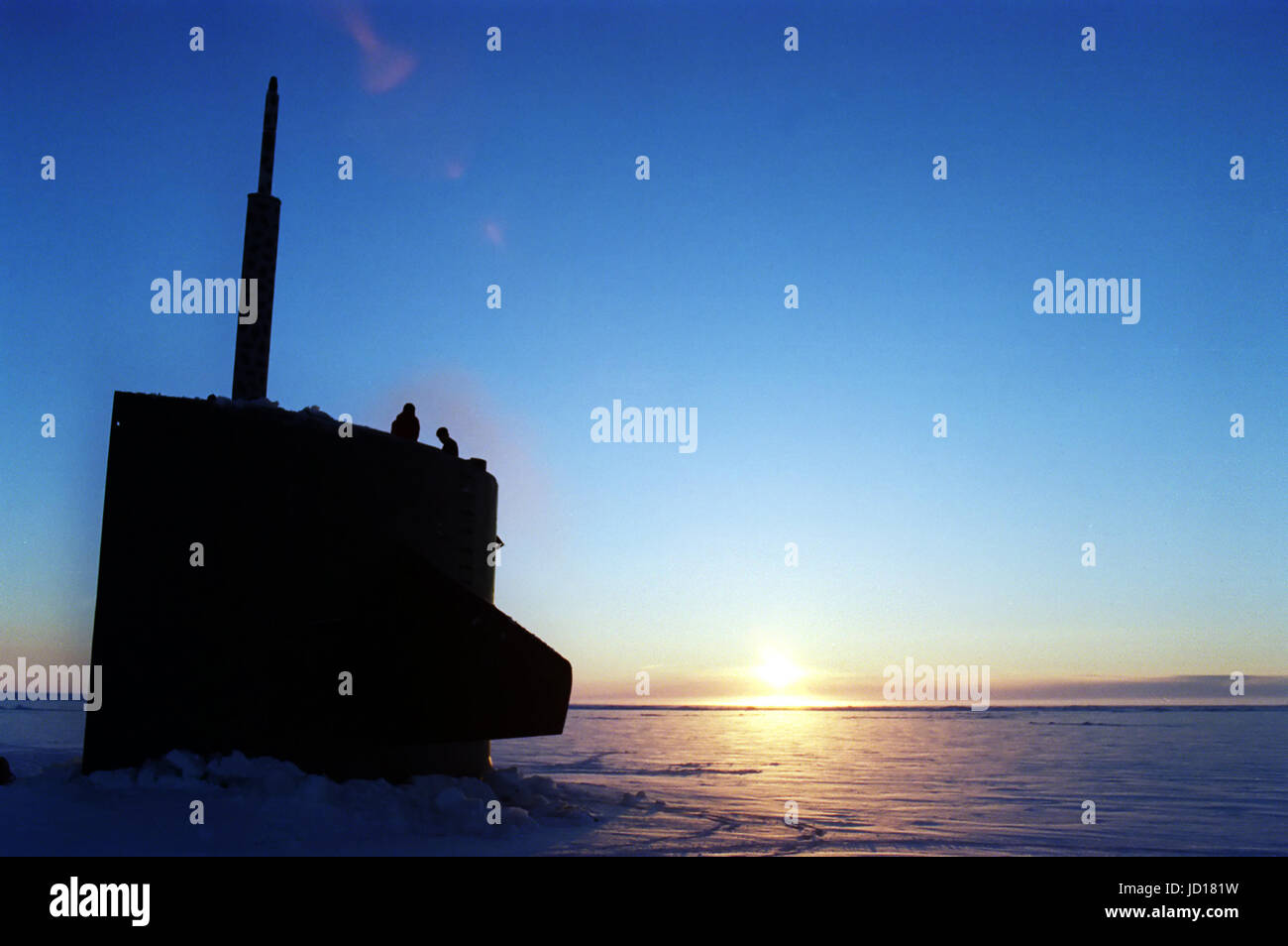 Deux membres de l'équipage de sous-marin d'attaque de l'USS Pogy (SSN 647) l'enquête entourant la glace après le lever du soleil à surface sous le biais d'une épaisse couche de 6 pouces de glace de l'Arctique. Le sous-marin est en mission de recherche au Pôle Nord. DoD photo de Maître de 2e classe Steven H. Vanderwerff, U.S. Navy Banque D'Images