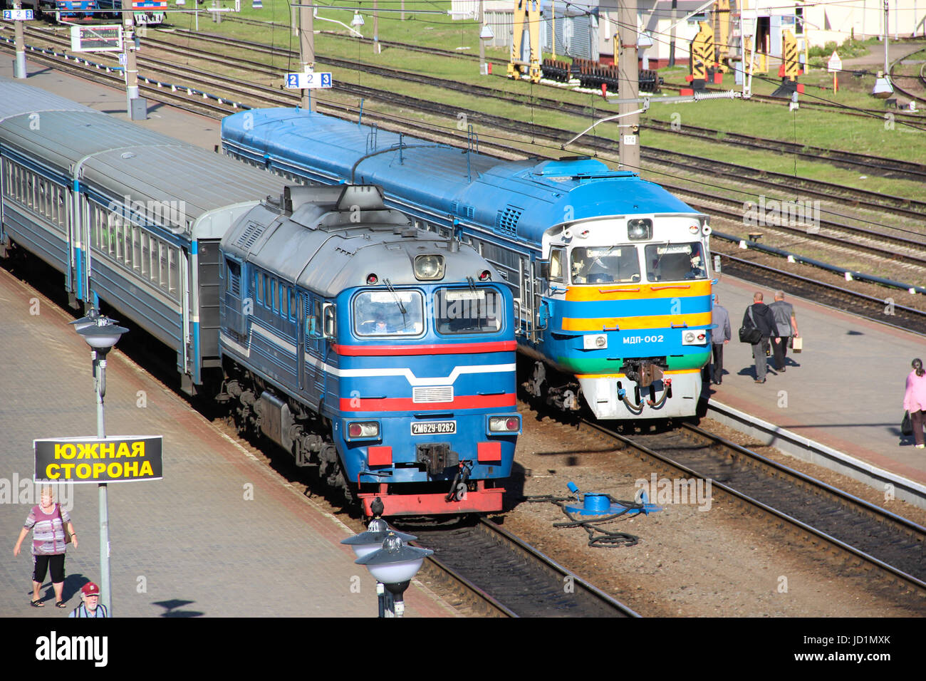 Les trains de banlieue électriques et diesel comité permanent sur les voies de la gare en attente de passagers. Soirée d'été Banque D'Images