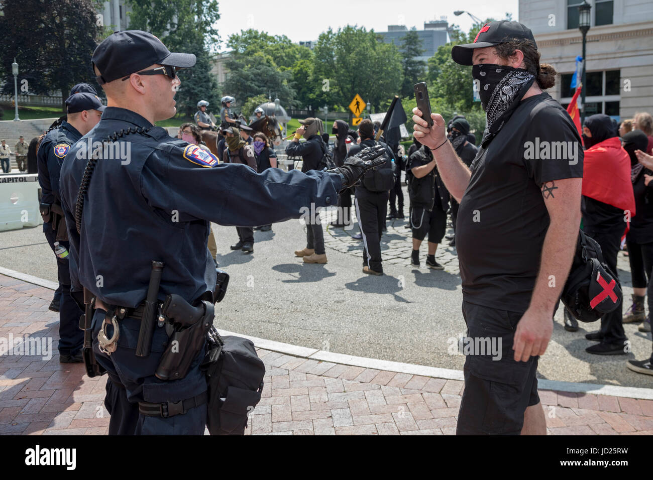 Harrisburg, Pennsylvanie - UN Black Bloc films anarchiste un officier de police au cours de la contre-manifestation du Bloc contre un anti-musulman, anti-charia r Banque D'Images