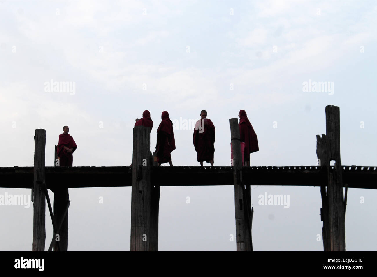 U-Bein Bridge/Amarapura - Myanmar 22 Janvier 2016 : cinq moines bouddhistes sur leur promenade quotidienne à travers les mondes plus long pont pied juste avant le lever du soleil. Banque D'Images