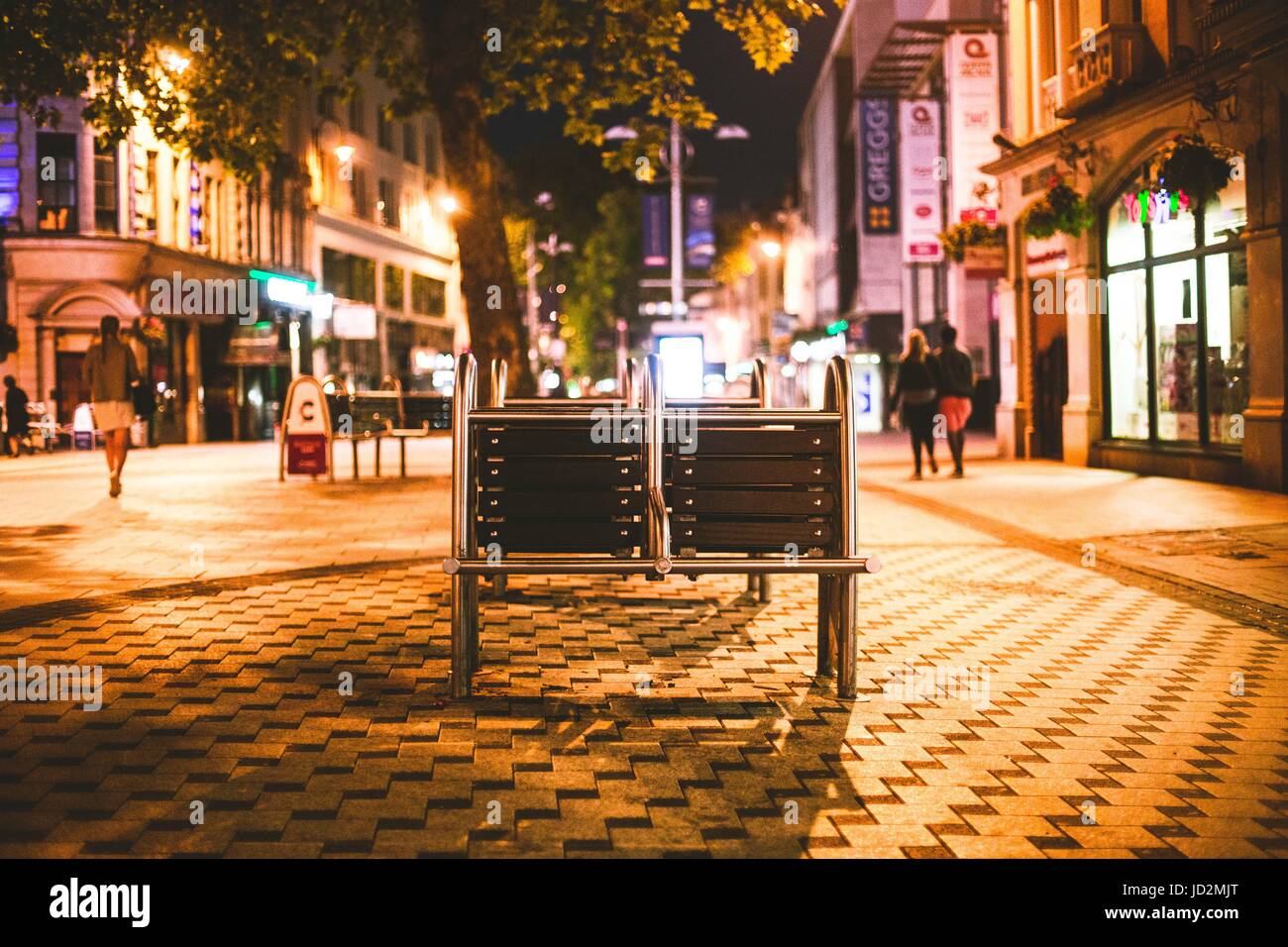 Photographie d'un banc dans la rue la nuit Banque D'Images