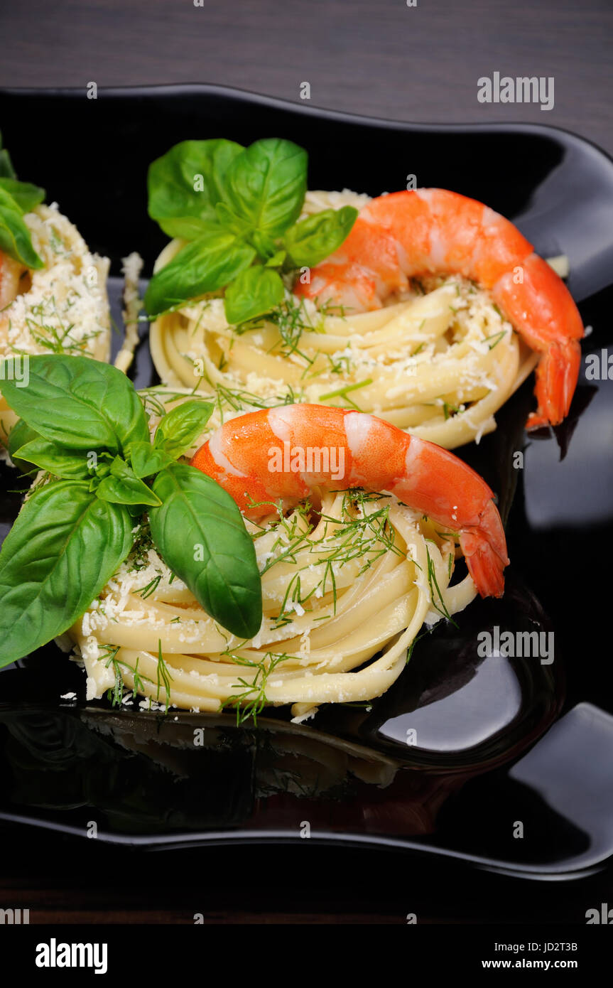 Nids de spaghetti de parmesan parfumée à l'aneth, basilic et crevettes. Banque D'Images
