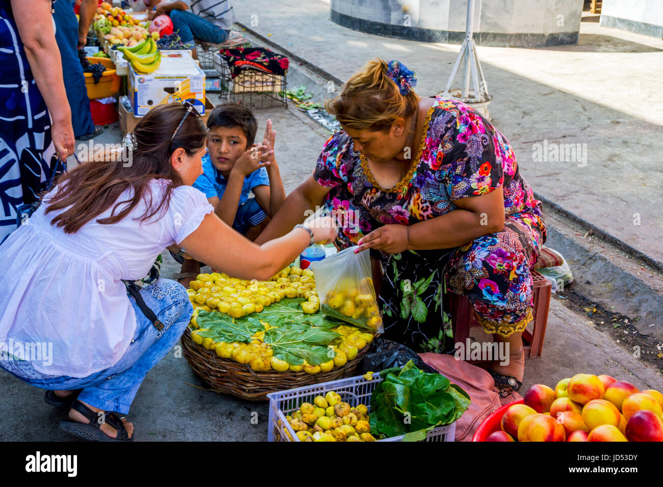 SAMARKAND, OUZBÉKISTAN - 28 août : Woman picking venu figues jaune du panier à Siab bazar, marché local, à Samarkand. Août 2016 Banque D'Images