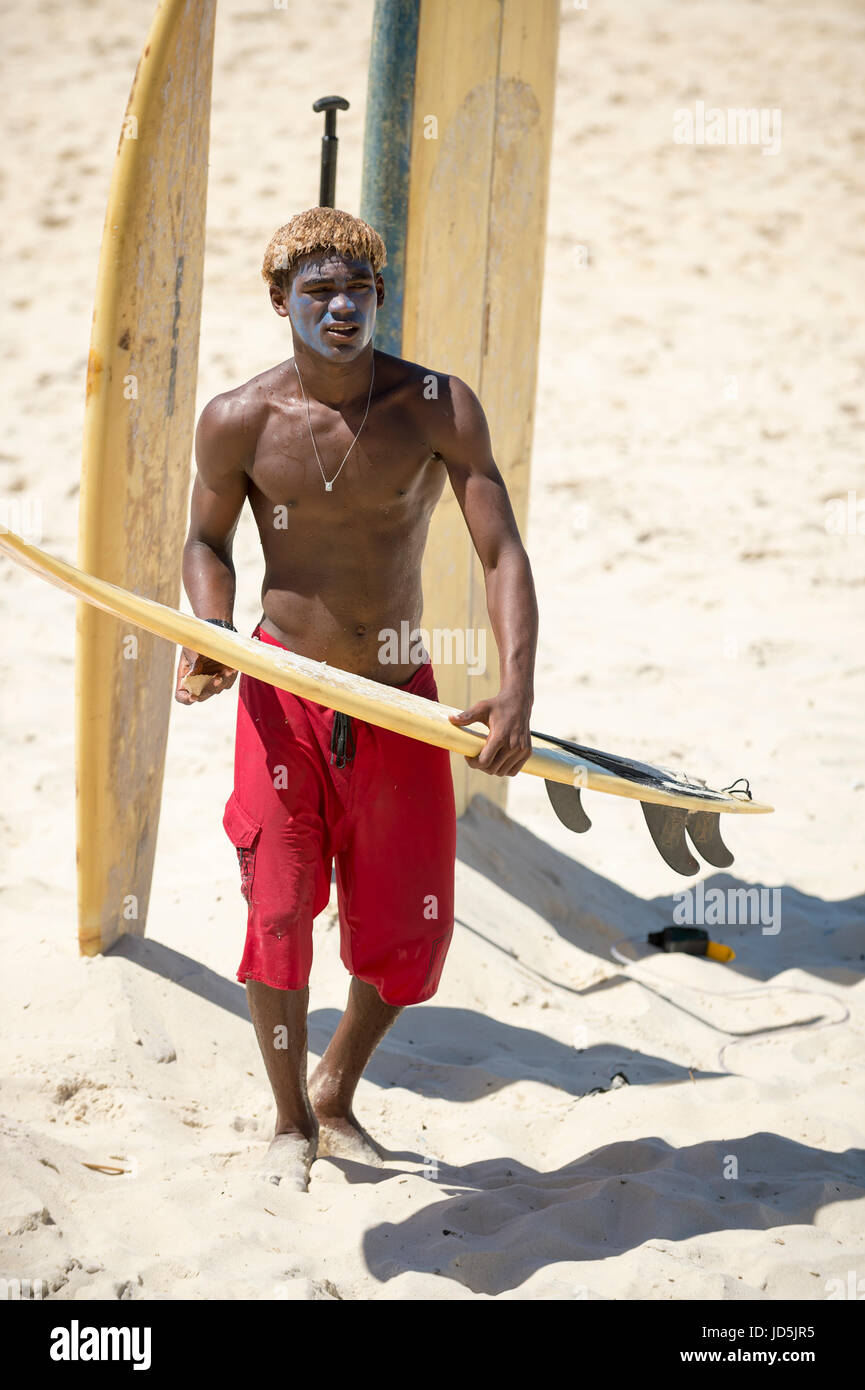 RIO DE JANEIRO - le 10 février 2017 : jeune surfeur brésilien ses cires de surf le long de la côte à l'Arpoador, spot de surf populaire. Banque D'Images
