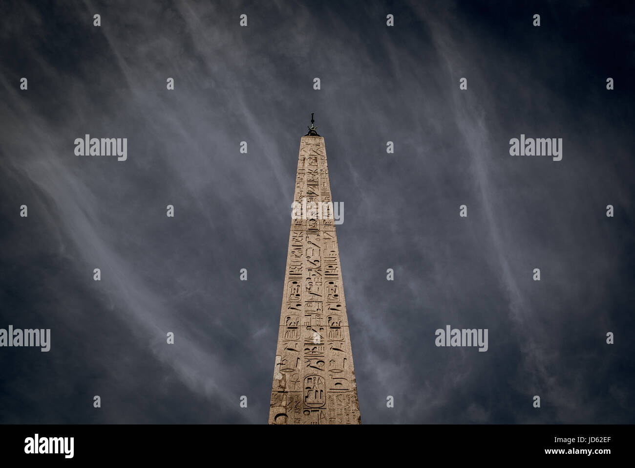 Le célèbre vieux obélisque en piazza del popolo Rome, vue depuis l'angle faible ciel dramatique Banque D'Images