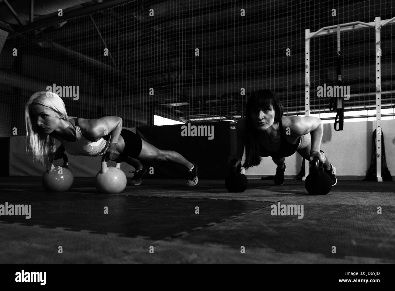 Jeune couple Exercising With électrique Bell et Flexing Muscles - Athletic musculaire Fitness Exercices Modèle Bodybuilder Banque D'Images