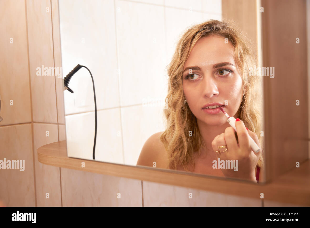 Une femme faisant un miroir et voir dans le reflet d'une salle de bains mirrow dans le matin Banque D'Images