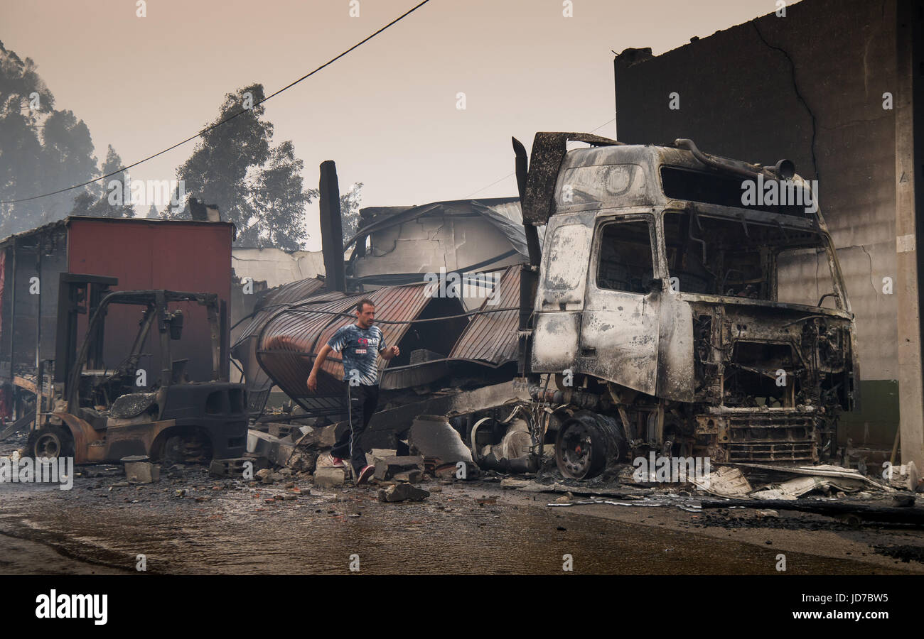 Moita, Portugal. 19 Juin, 2017. Un homme marche par une usine à bois avec un camion carbonisé dans le nord-est de Lisbonne, à Moita, Portugal, 19 juin 2017. Selon des sources policières le feu de forêt qui a tué de nombreuses personnes a été commencé par la foudre. Dpa : Crédit photo alliance/Alamy Live News Banque D'Images