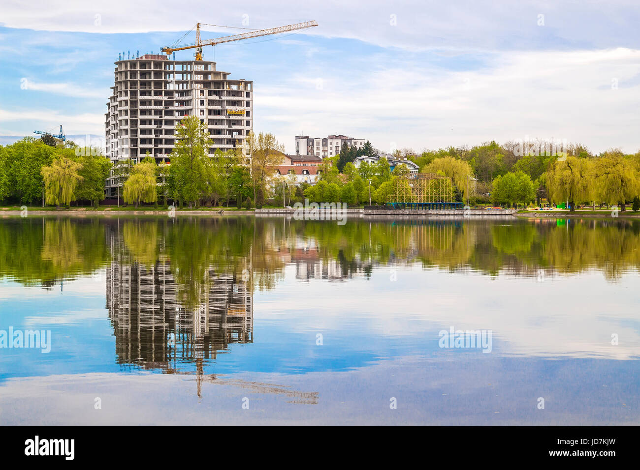 De nouveaux gratte-ciel moderne en construction sur les rives d'un lac. La réflexion de bâtiment en béton dans l'eau Banque D'Images