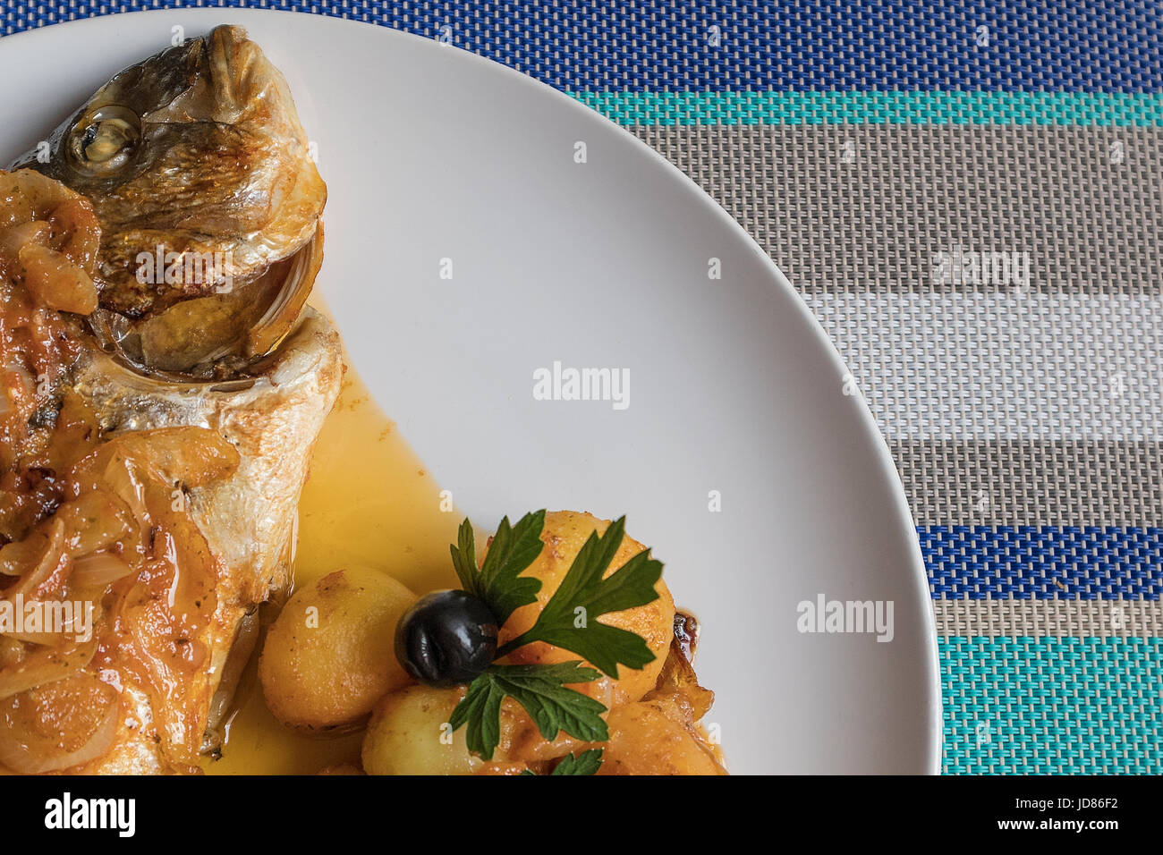 Le poisson cuit au four, accompagné de pommes de terre à l'or et les