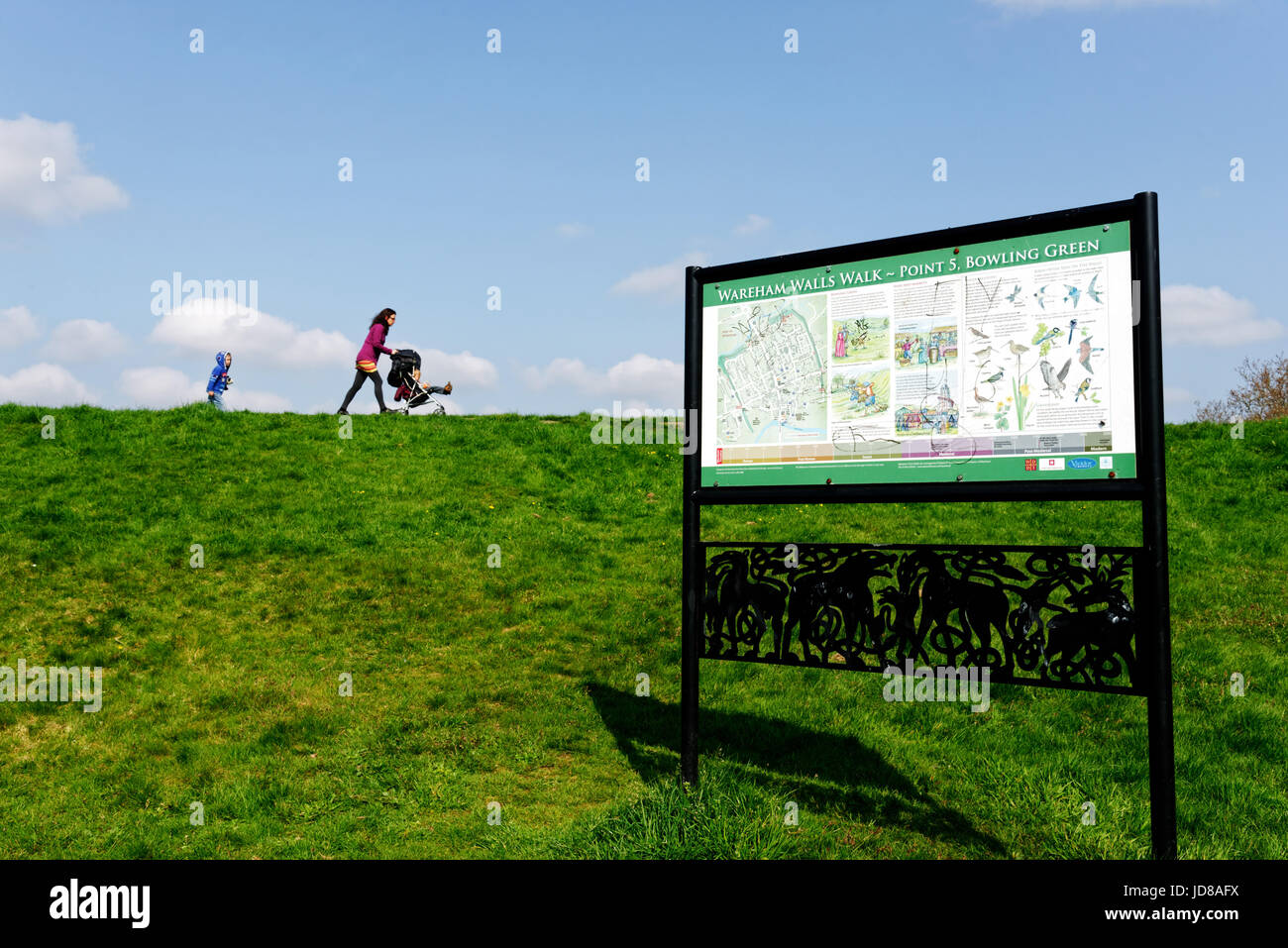 Un enfant et une femme poussant une poussette le long des murs à pied à Wareham Wareham, Dorset, Angleterre Banque D'Images