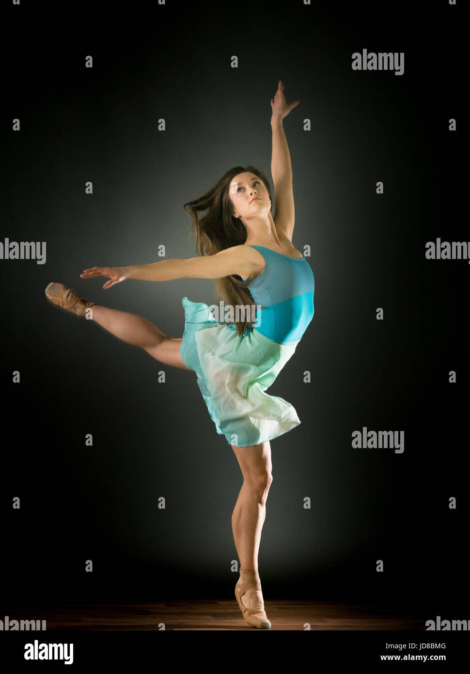Femme ballerine sur une jambe avec les bras tendus, studio shot. caucasian monter assez maigre athletic Banque D'Images