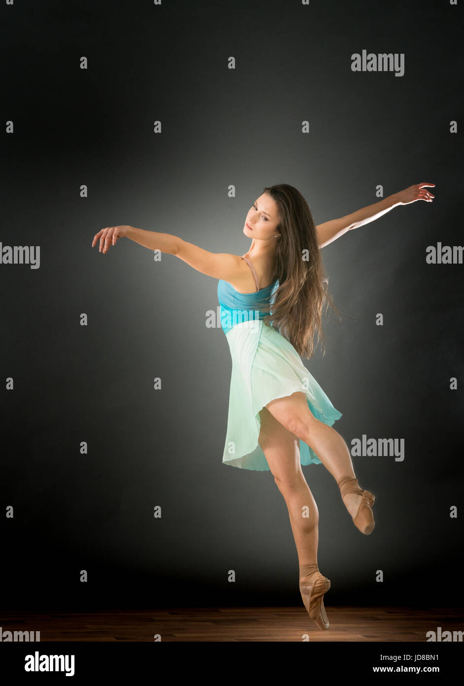 Femme ballerine sur une jambe avec les bras tendus, studio shot. caucasian monter assez maigre athletic Banque D'Images