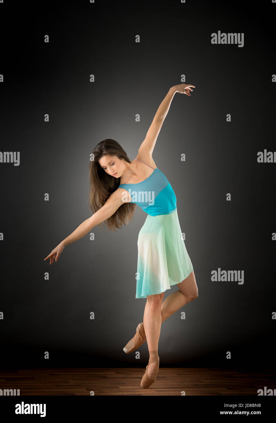 Ballerine Femme avec bras étendus sur une jambe à la recherche vers le bas, studio shot. caucasian monter assez maigre athletic Banque D'Images