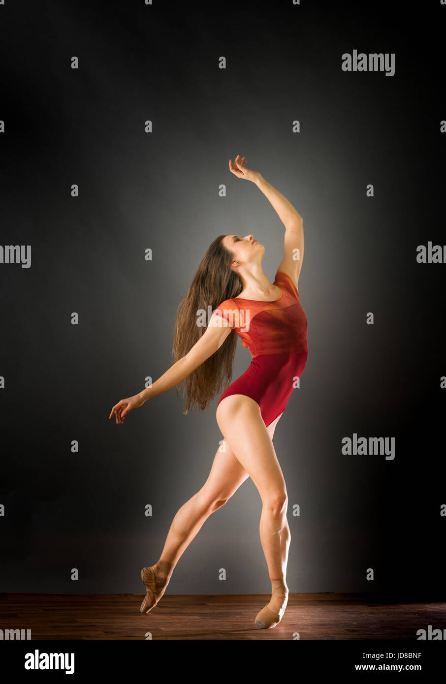 Femme danseuse de ballet s'adossant à la recherche jusqu'à bras tendus, studio shot. caucasian monter assez maigre athletic Banque D'Images