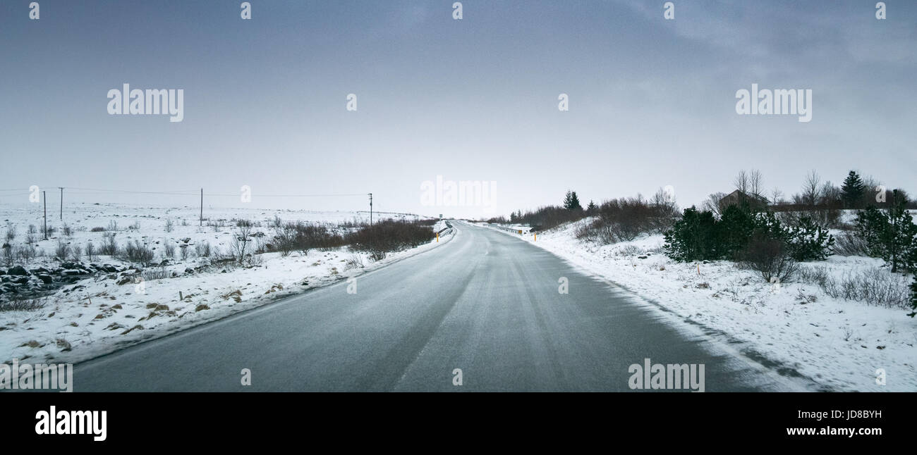 Sombre paysage enneigé, route et ciel orageux à jour, l'Islande, l'Europe. Nature de l'Islande 2017 hiver froid Banque D'Images