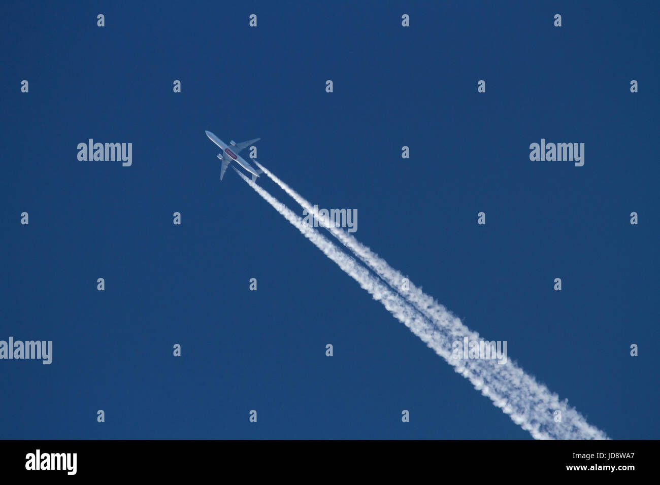 Les voyages aériens et l'environnement. Unis Boeing 777 avion à réaction volant haut dans le ciel et la génération d'une traînée de condensation dans l'air Banque D'Images