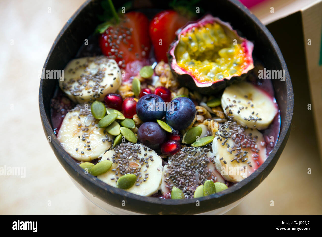 Petit-déjeuner sain bol avec de l'air - chia, bananes, bleuets, graines, citrouille, fruit de la passion et les fraises Banque D'Images