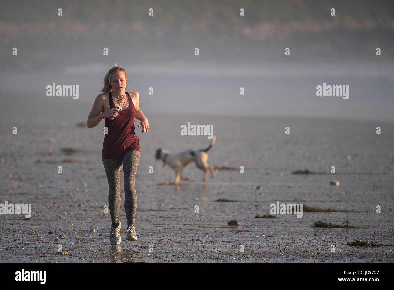 Une femme du jogging le long de la plage de Fistral, Newquay, Cornwall. Banque D'Images