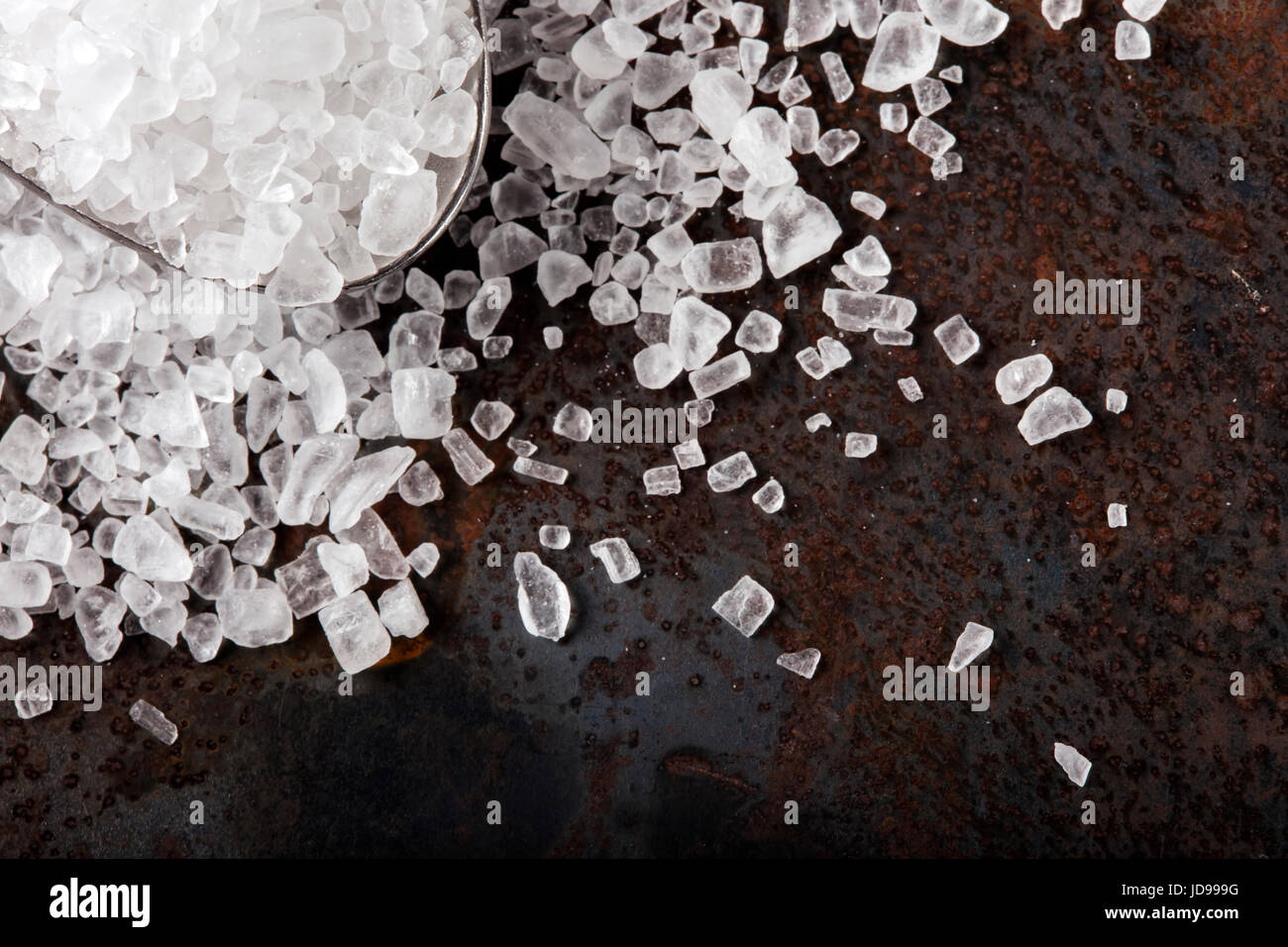 Close up de sel de mer dans la cuillère sur acier inoxydable rusty background Banque D'Images