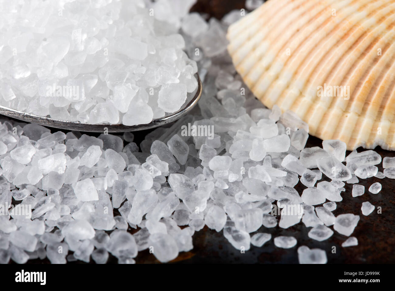 Close up de sel de mer dans la cuillère sur acier inoxydable rusty background Banque D'Images