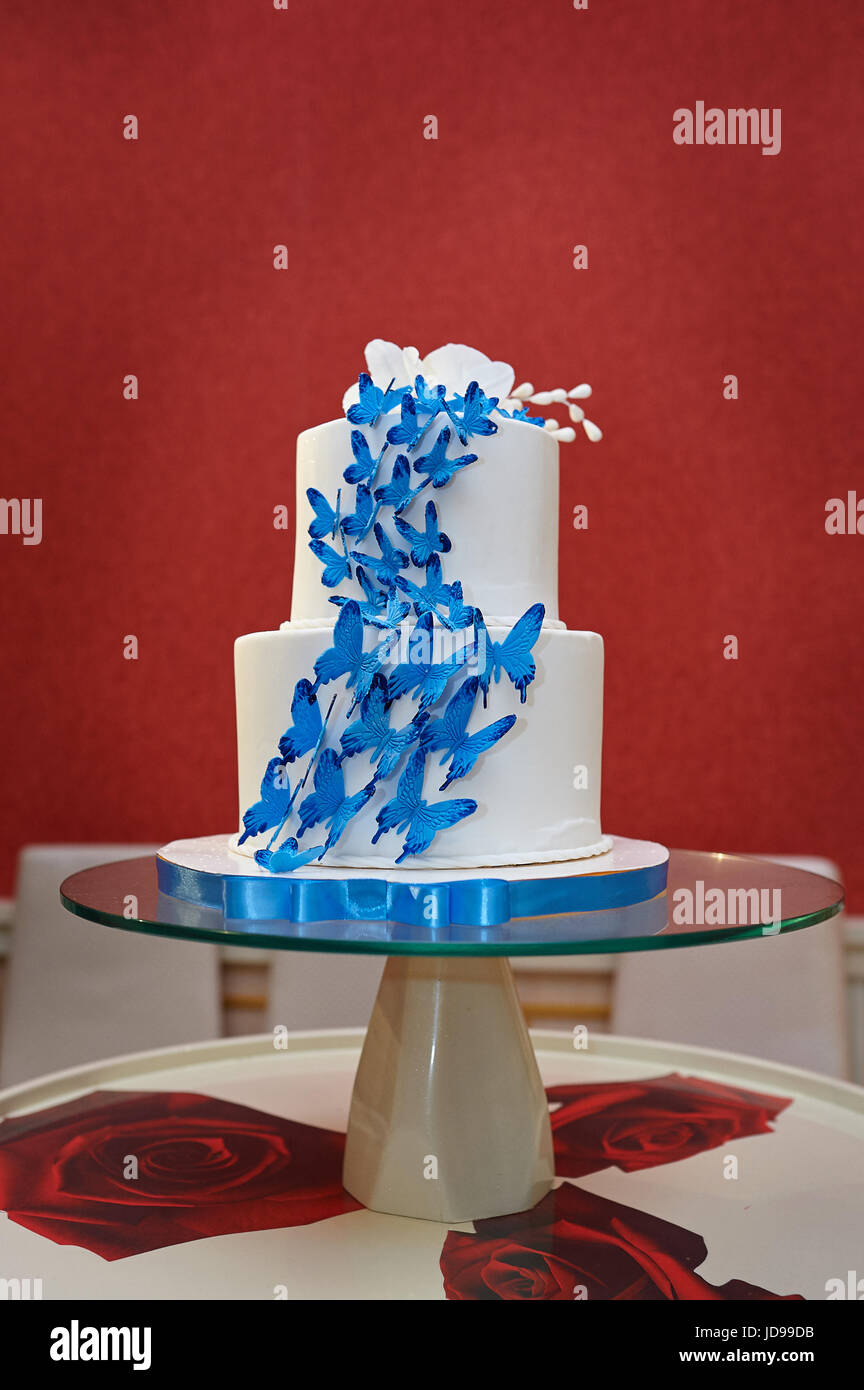 Gâteau de mariage avec des papillons bleus sur des verres table. Banque D'Images