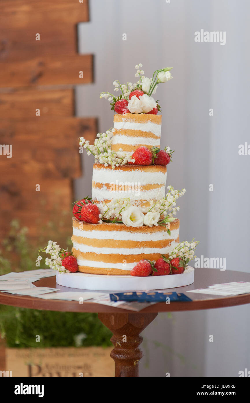 Gâteau de mariage avec des fleurs sur table en bois Banque D'Images