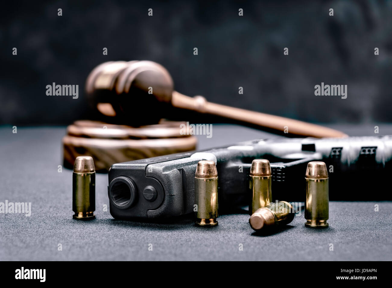 Un pistolet avec des balles symbolisant l'homme d'armes à feu alors qu'encadrée avec un marteau du juge et du bloc. Banque D'Images