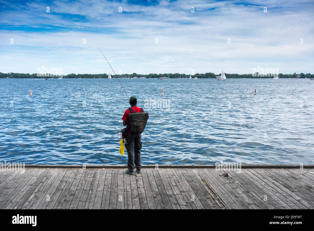 Personne debout sur la jetée de pêche de portefeuille de pêche sac à dos port vue arrière Ontario Canada Banque D'Images