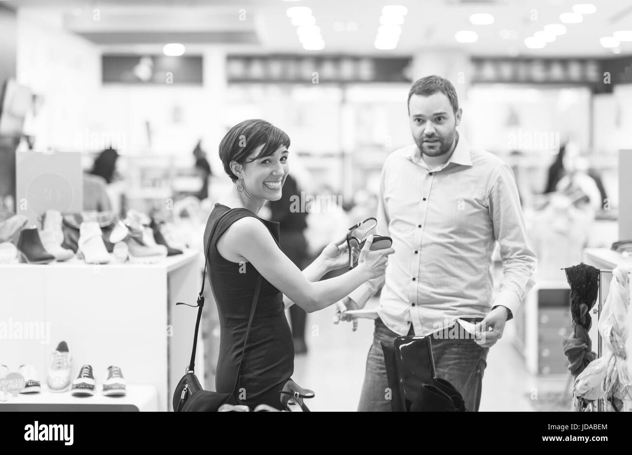 Un jeune beau couple change le regard avec de nouvelles chaussures Magasin de chaussures à Banque D'Images