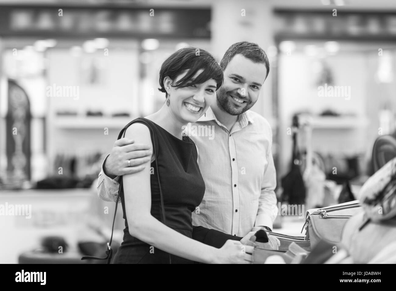 Un jeune beau couple change le regard avec de nouvelles chaussures Magasin de chaussures à Banque D'Images