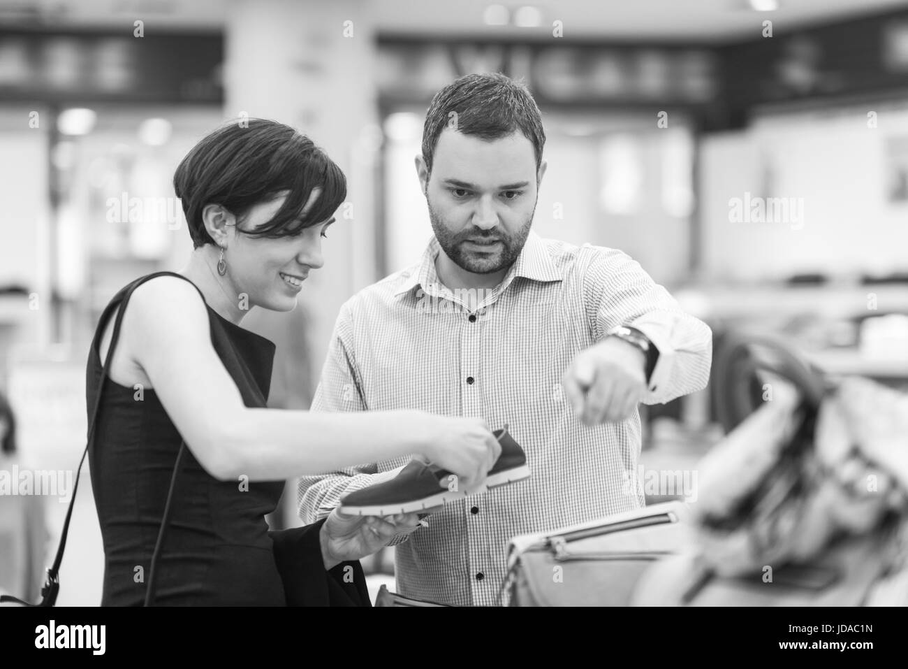 Un jeune beau couple change le regard avec de nouvelles chaussures Magasin de chaussures à Banque D'Images