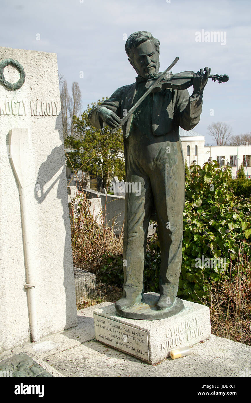 Statue d'un homme jouant du violon sur une tombe dans un cimetière Banque D'Images