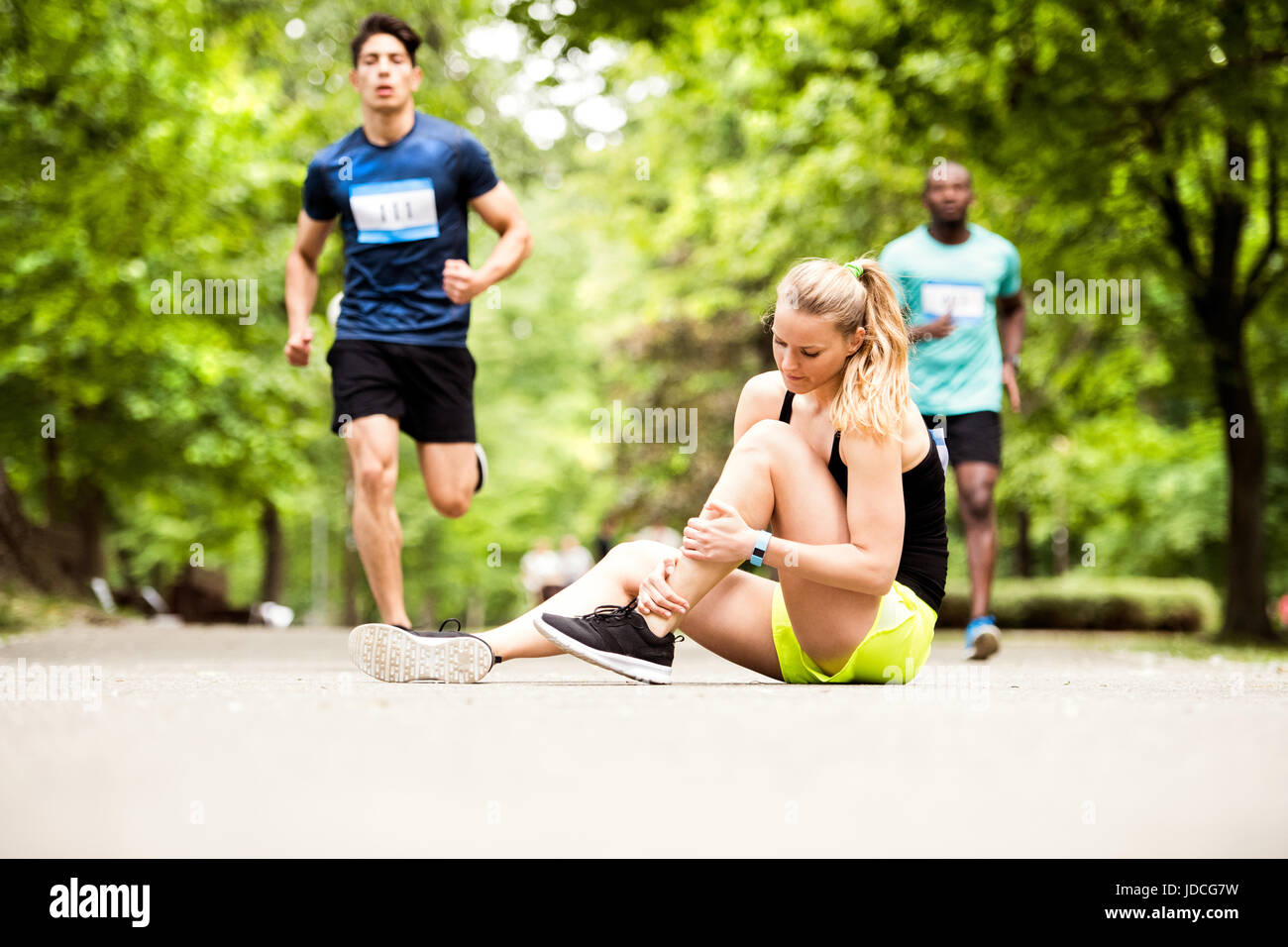 Jeune femme de la concurrence avec l'entorse de cheville. Banque D'Images