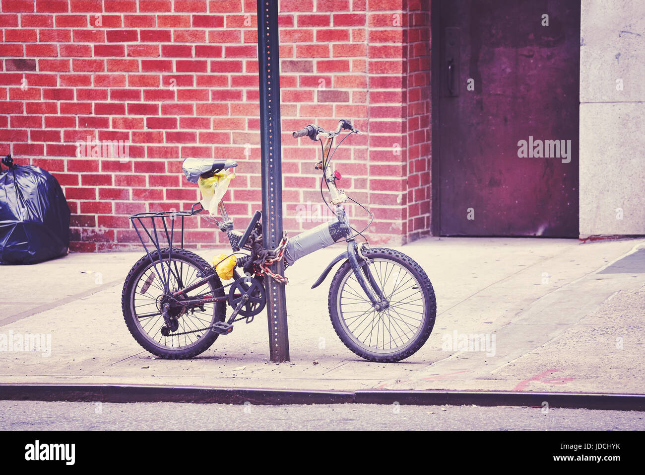 Stylisé couleur vieux vélo verrouillé sur un poteau de signalisation de la rue dans le quartier chinois, la ville de New York, USA. Banque D'Images