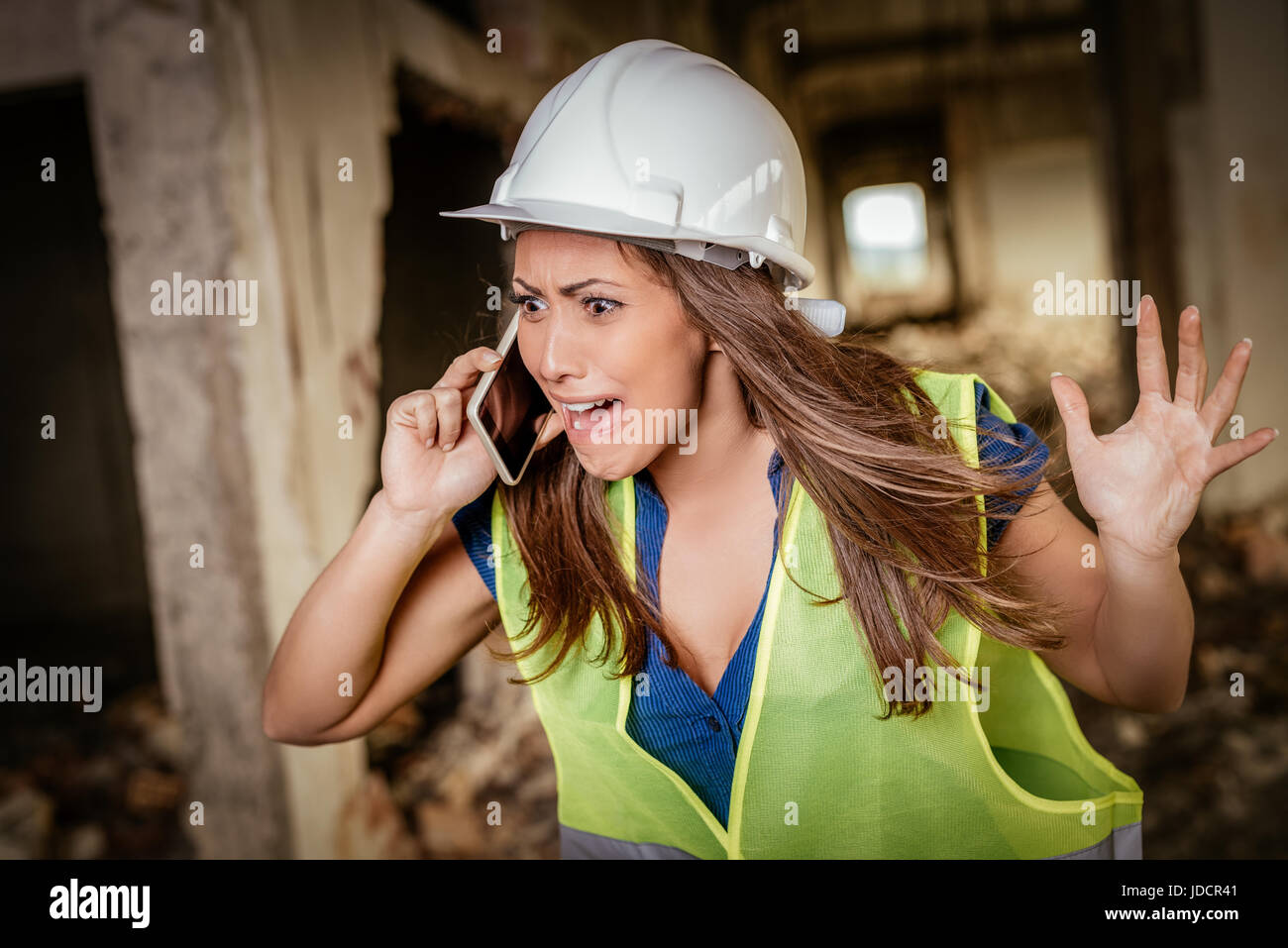 De belles jeunes femmes architectes de la construction à l'aide de Phone sur un chantier de construction. Banque D'Images