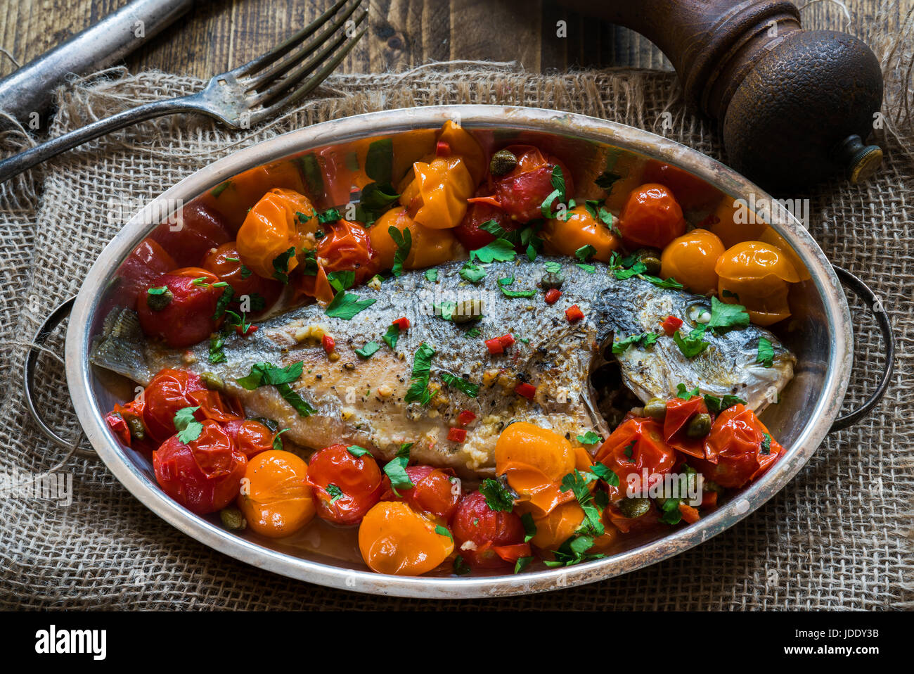 Style Italien brème de mer dans de l'eau folle - acqua pazza - sur table en bois Banque D'Images