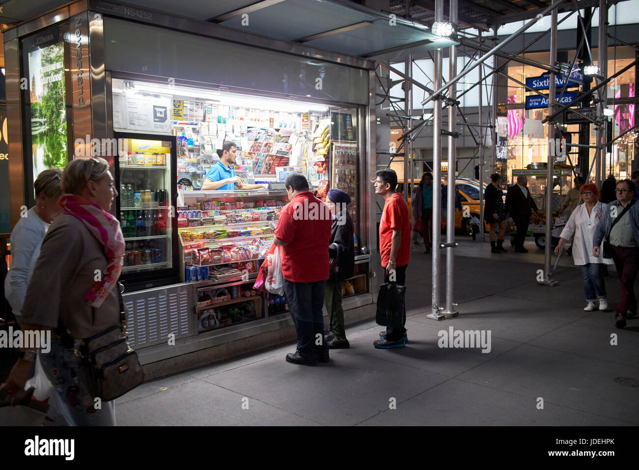 Clients à un newstand de nuit New York USA Banque D'Images