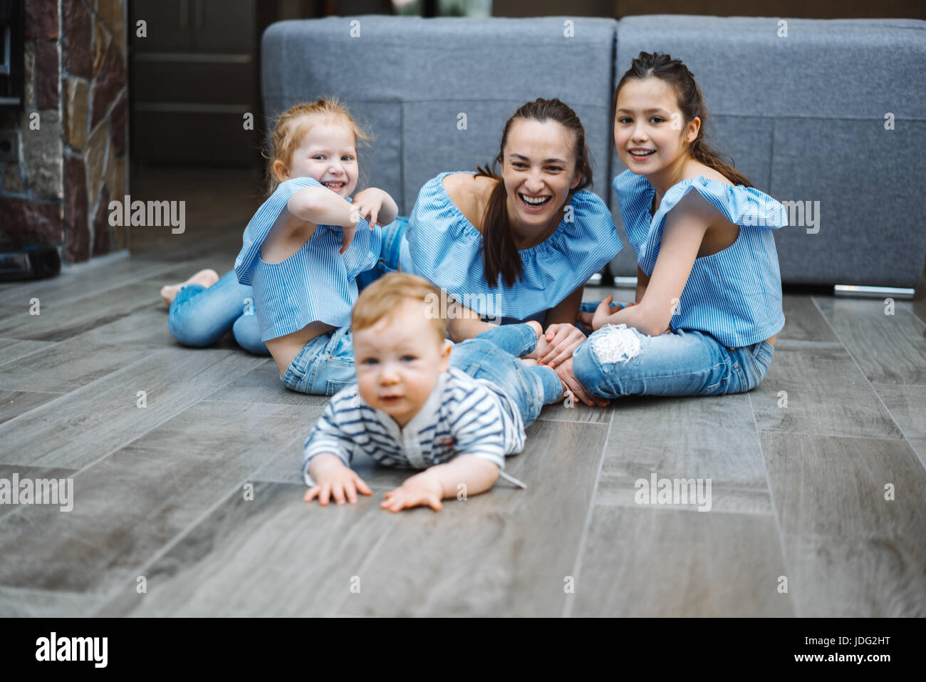 Maman, deux filles et un petit garçon sur le sol Banque D'Images