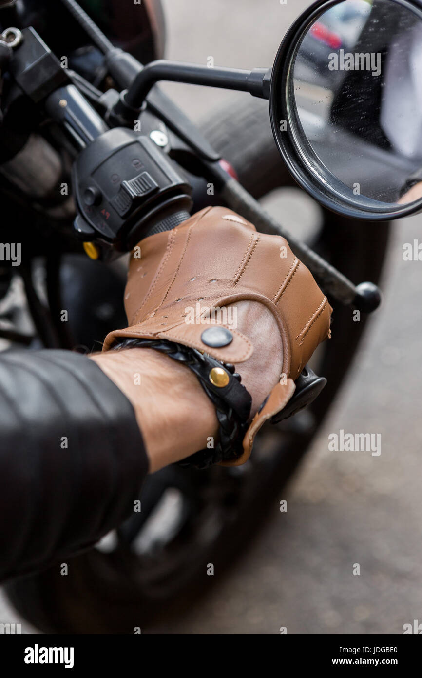 Libre d'une main dans l'homme biker hippie gant pour maintenir la commande  de l'accélérateur de style classique du cafe racer moto. En fait sur  commande de vélo vintage garage Photo Stock -