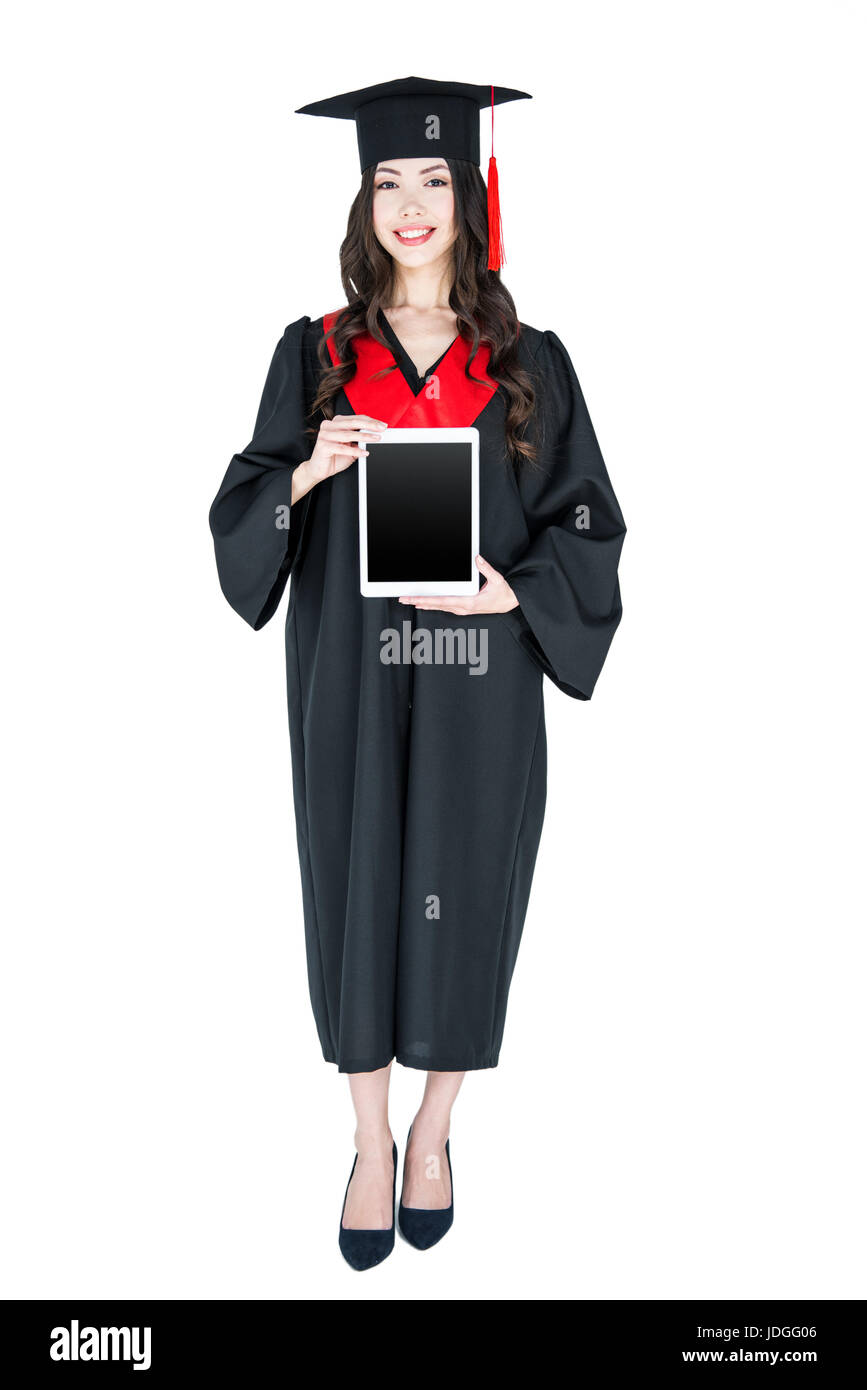 Belle jeune femme brune en mortier holding digital tablet and smiling Banque D'Images