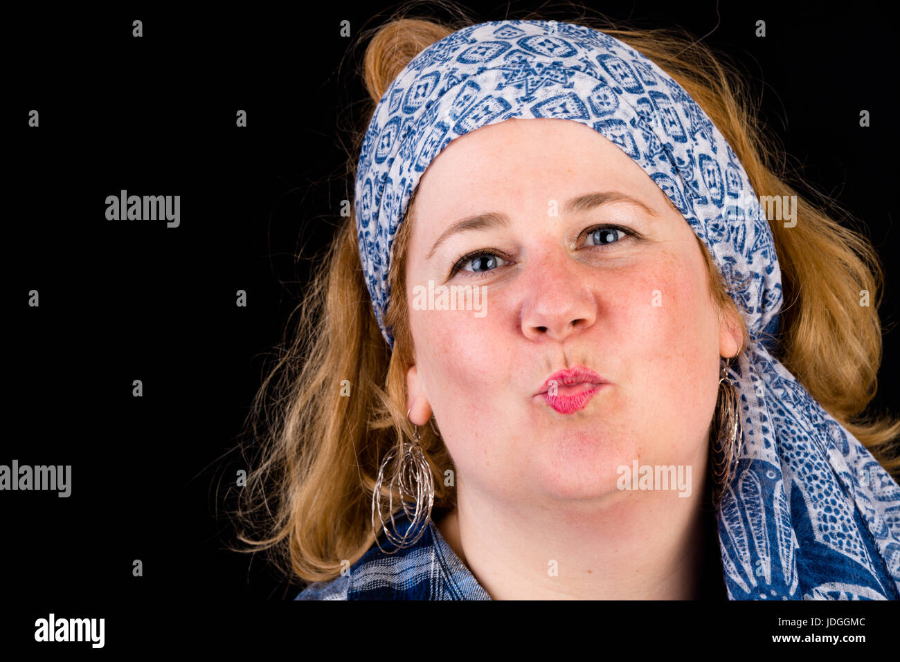 Portrait d'une jolie lumière européenne surpondérés red haired femme l'envoi de baisers, portant chemise bûcheron bleu et foulard bleu comme la coiffure, les chefs Banque D'Images