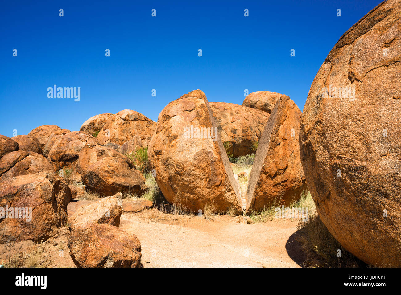 Devils Marbles - rochers de granit rouge est équilibré sur substrat rocheux, l'Australie, Territoire du Nord. Banque D'Images