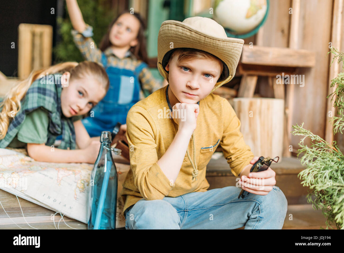 Mignon les enfants jouant avec la carte de chasse au trésor sur le porche Banque D'Images