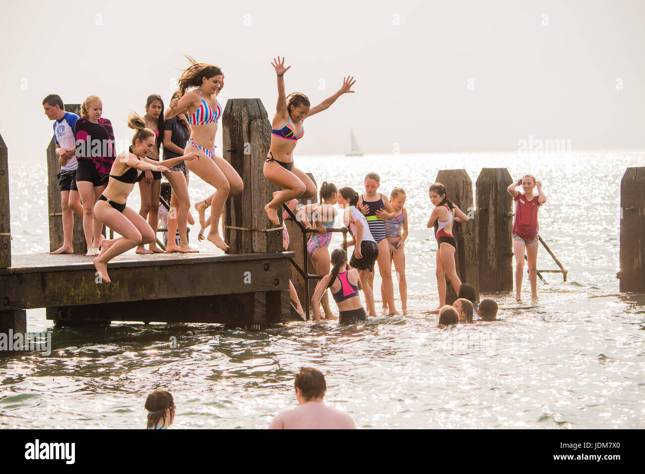 Pays de Galles Aberystwyth UK, mercredi 21 juin 2017 Météo Royaume-uni : Des groupes de jeunes garçons et filles de se rafraîchir en se jetant dans la mer au large de la jetée à Aberystwyth au terme Solstice, et ce qui devrait être le dernier jour de la période en cours du chaud et sensuel comme la météo mini vague de chaleur qui se poursuit aujourd'hui au-dessus des îles britanniques. Le Met Office a mis en garde contre de fortes pluies et d'orages avec la possibilité d'inondations localisées qui affectent une grande partie du Royaume-Uni dans les prochaines 24 heures que le temps commence à se décomposer après plusieurs jours de températures record hight Crédit : Keith morris/Alamy Live News Banque D'Images