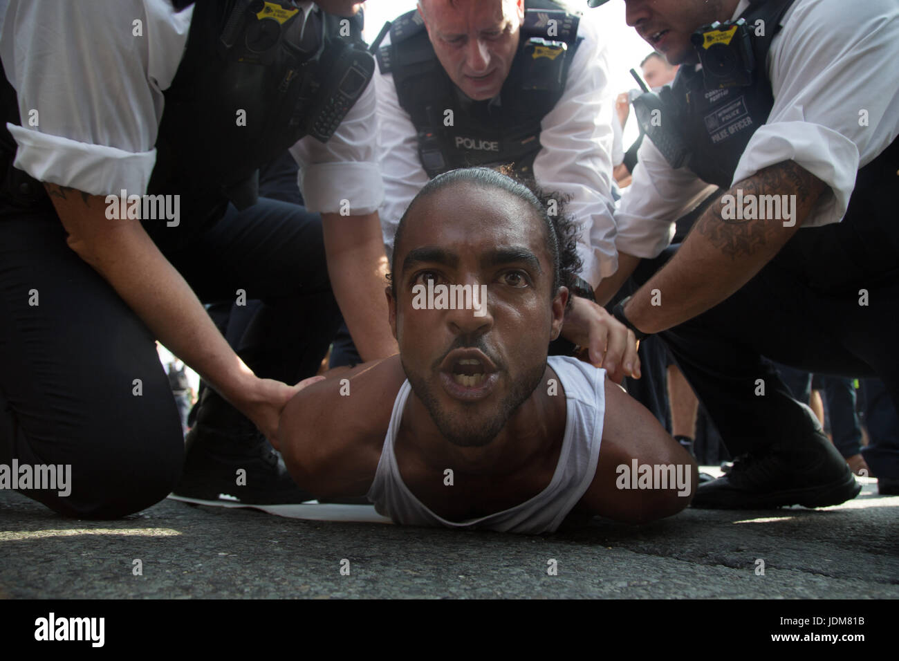 London UK 21 Juin 2017 Un homme est arrêté par des agents de police de recueillir des manifestants dans la place du Parlement pour les victimes de l'incendie dévastateur de la semaine dernière dans une tour à l'ouest de Londres. Soixante-dix-neuf personnes sont mortes ou portées disparues et présumées mortes. Mais les gens disent que le nombre de morts est beaucoup plus élevé. La protestation contre le gouvernement intitulé Jour de rage a coïncidé avec l'ouverture du Parlement. Banque D'Images